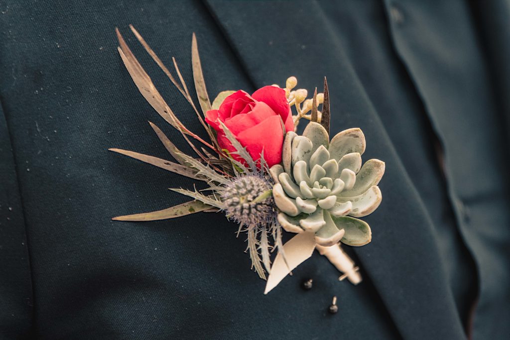Succulent and red rose boutonnière for the grooms jacket 
