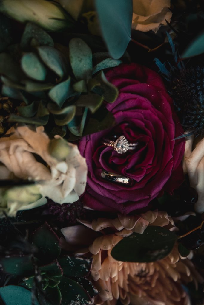 His and her wedding rings inside a succulent filled wedding bouquet