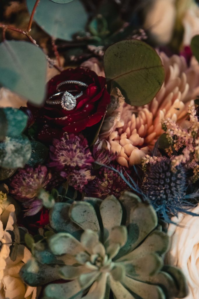 Wedding bouquet with succulents and wedding rings for this detail shot