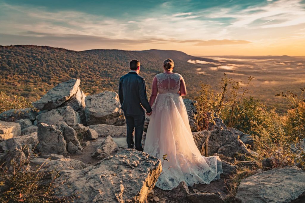 The bride and groom take in this beautiful view from an overlook at sunrise during their Pennsylvania hiking elopement.