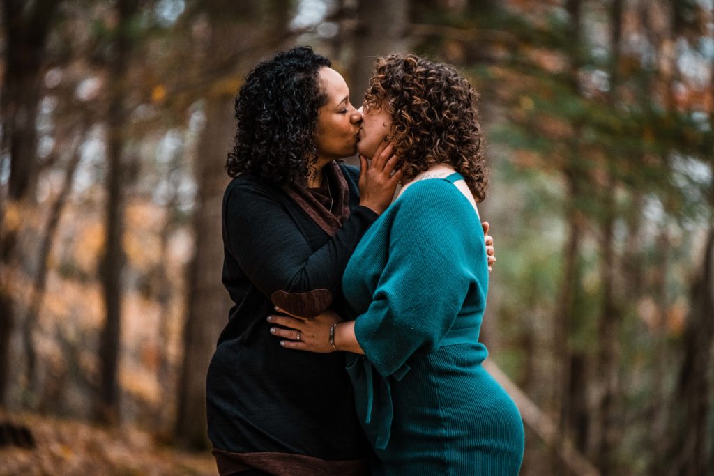 Ending the shoot the right way,  very much in love, this lesbian couple kisses for the camera to finish their engagement portraits.