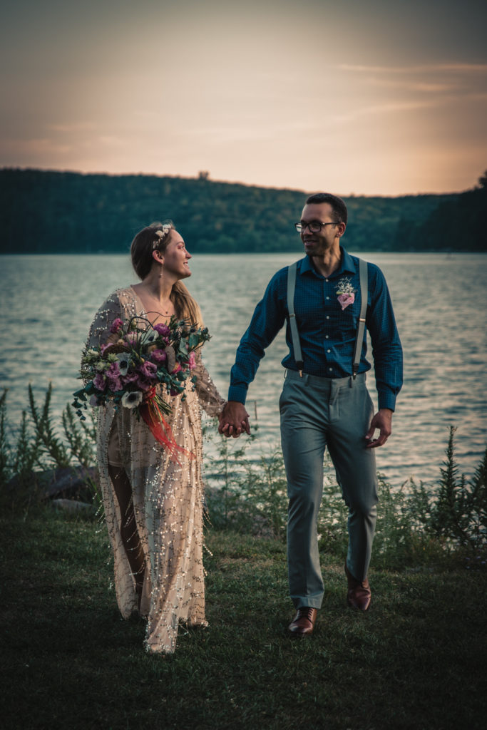 An eloping couple hold hands and walks towards the camera after their Wisconsin elopement in Devils Lake State Park