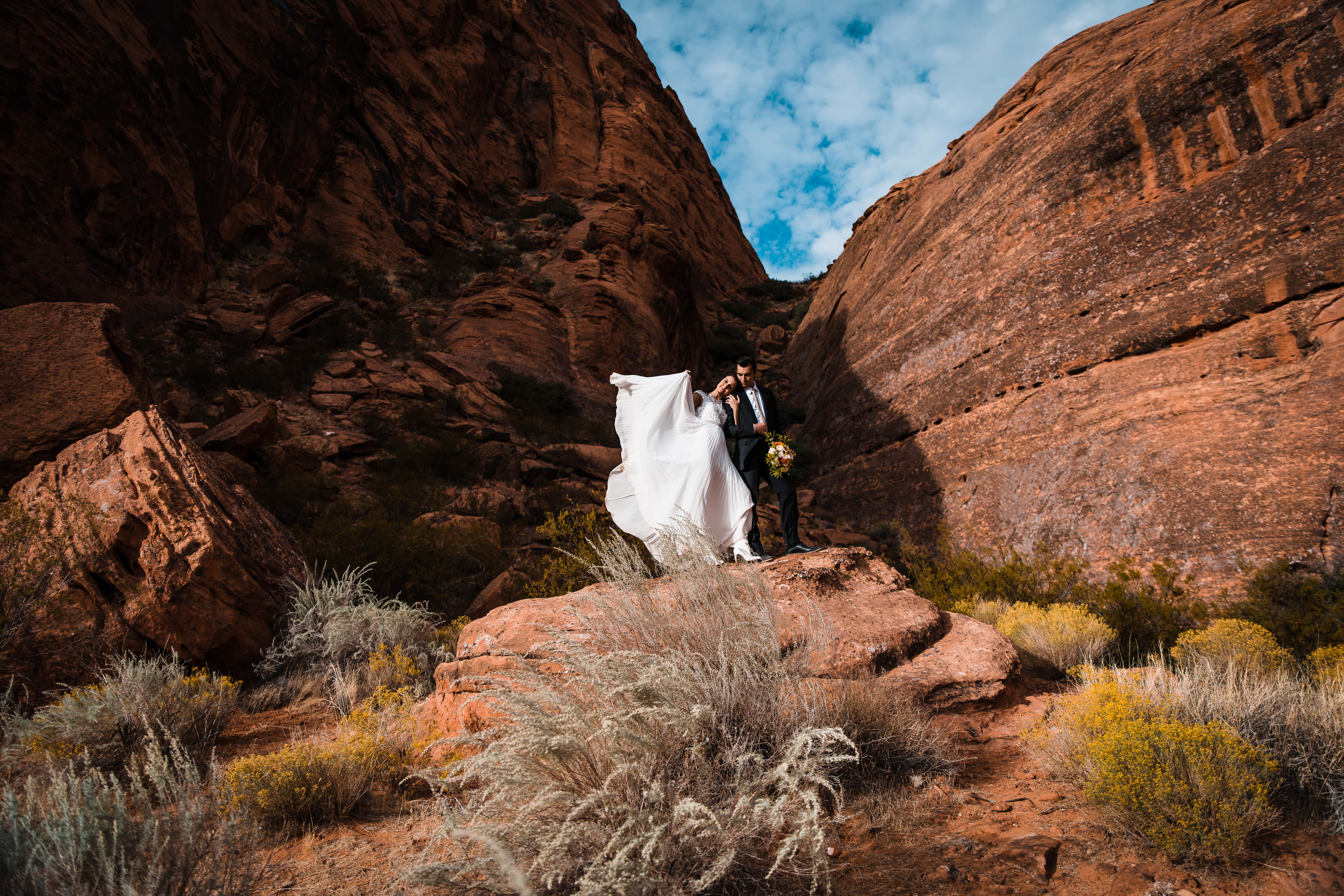 Posing in Utah's red rocks, a couple poses after their elopement